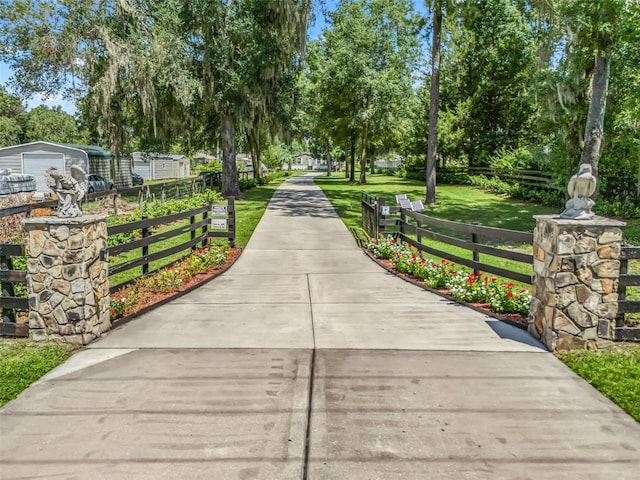 surrounding community with a yard, a detached garage, and fence