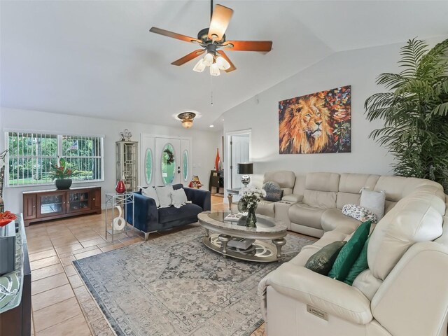 living room featuring lofted ceiling, ceiling fan, and light tile patterned floors