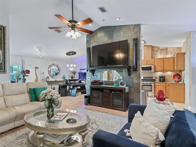 tiled living room featuring ceiling fan with notable chandelier and vaulted ceiling