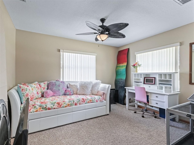 carpeted bedroom with ceiling fan, visible vents, and a textured ceiling