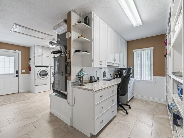 kitchen featuring a textured ceiling, separate washer and dryer, light tile patterned floors, and white cabinetry