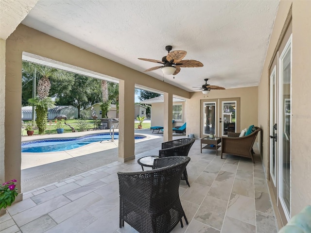 view of patio / terrace featuring a ceiling fan, french doors, and an outdoor pool