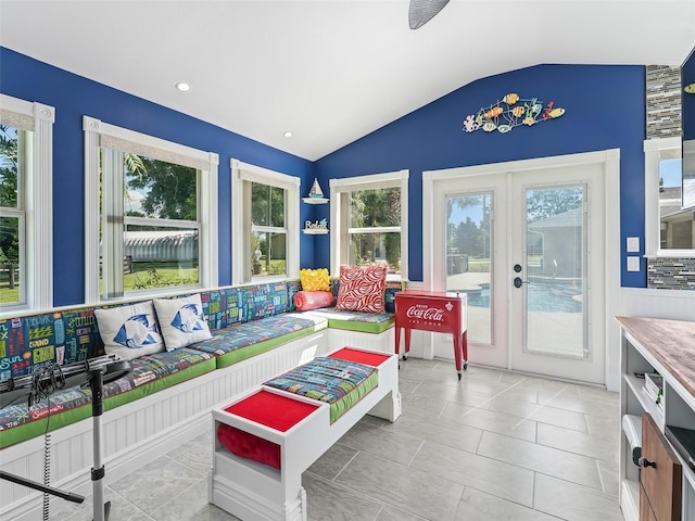 sunroom featuring lofted ceiling, a wealth of natural light, and french doors