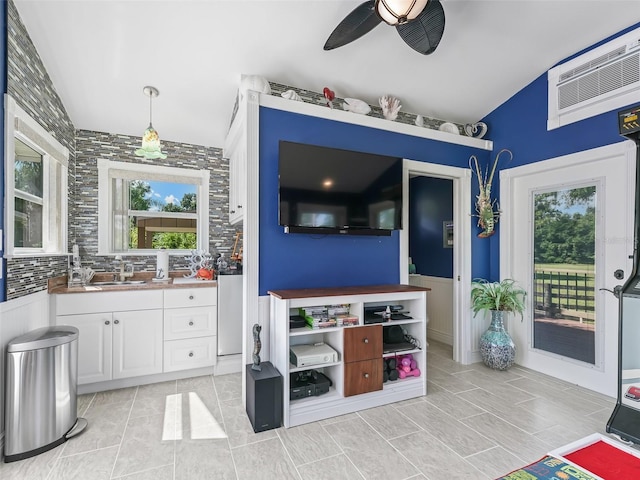 interior space featuring tile patterned floors, vanity, tasteful backsplash, ceiling fan, and vaulted ceiling