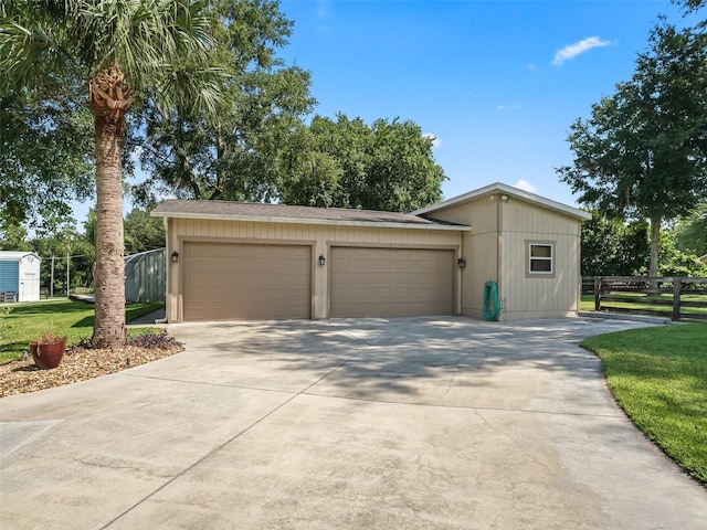 view of front of property with driveway, an attached garage, fence, and a front yard