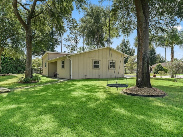 view of home's exterior with a yard and a trampoline