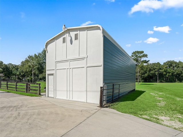 view of barn with a yard and fence