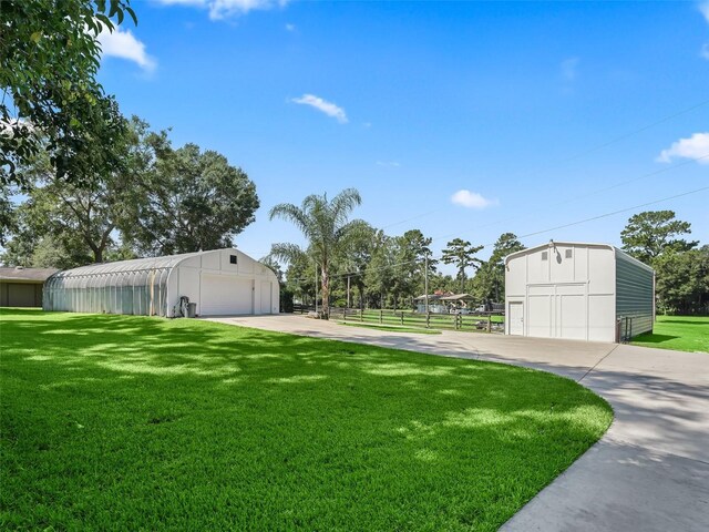 view of yard featuring a garage and an outbuilding