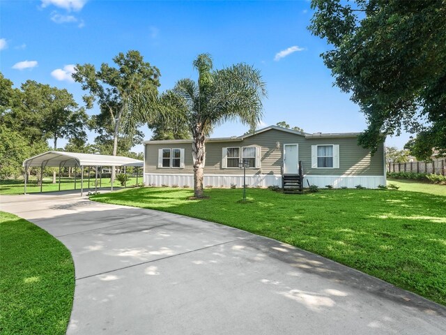 manufactured / mobile home with a carport and a front yard