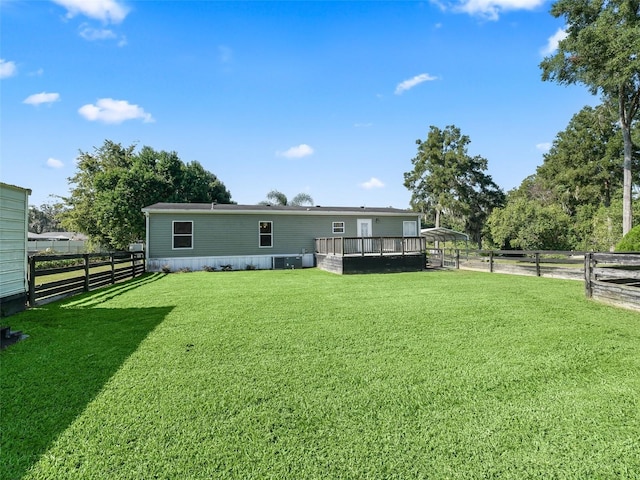 back of property featuring a yard, a deck, and fence