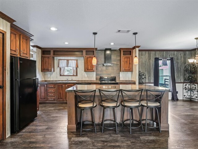 kitchen featuring black refrigerator, electric range oven, a kitchen island, dark hardwood / wood-style floors, and wall chimney range hood