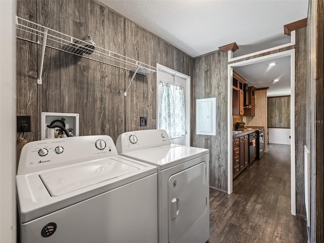 clothes washing area with a textured ceiling, laundry area, dark wood-style flooring, electric panel, and washer and clothes dryer