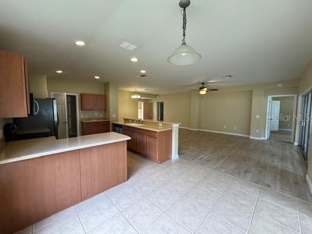 kitchen with sink, light wood-type flooring, ceiling fan, pendant lighting, and refrigerator