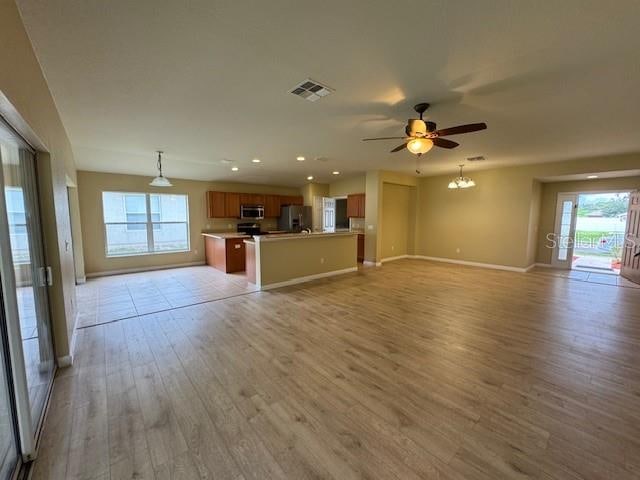 unfurnished living room with light hardwood / wood-style flooring and ceiling fan