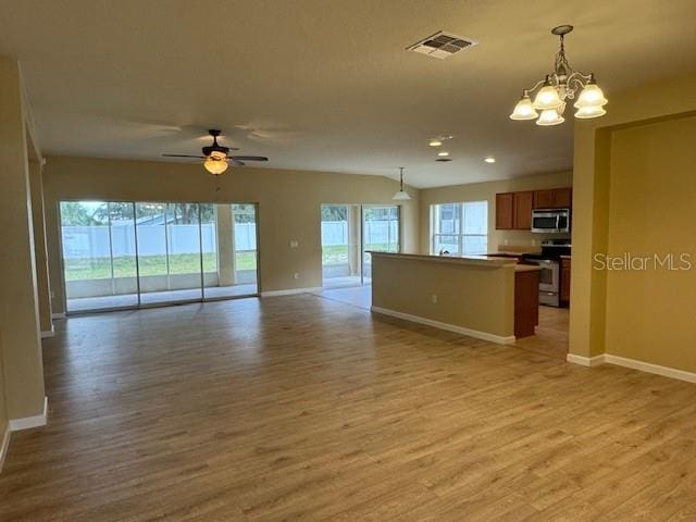 kitchen with light hardwood / wood-style floors, stove, and a healthy amount of sunlight