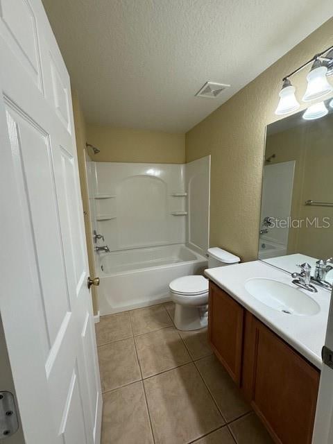 full bathroom featuring tile patterned floors, a textured ceiling, vanity, and toilet