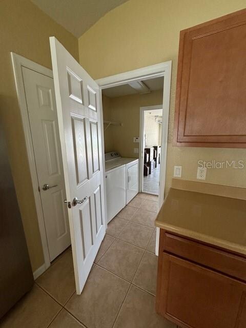 washroom featuring washing machine and dryer and light tile patterned floors