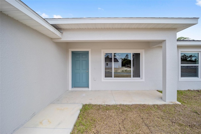 property entrance featuring a lawn