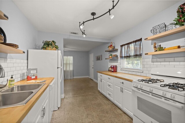 kitchen featuring butcher block counters, rail lighting, tasteful backsplash, white cabinets, and white appliances