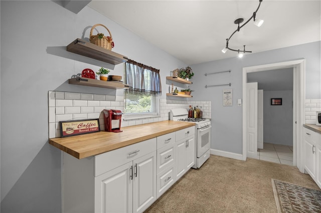 kitchen with wood counters, tasteful backsplash, white range with gas cooktop, and white cabinetry