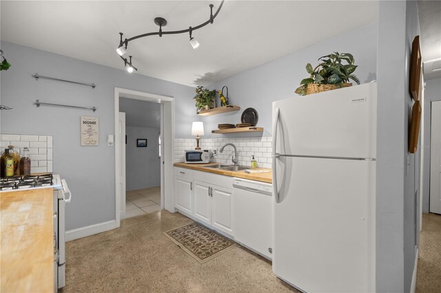 kitchen with decorative backsplash, white cabinets, track lighting, sink, and white appliances