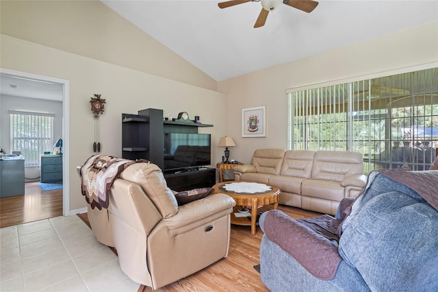 living room with plenty of natural light, vaulted ceiling, ceiling fan, and light hardwood / wood-style floors