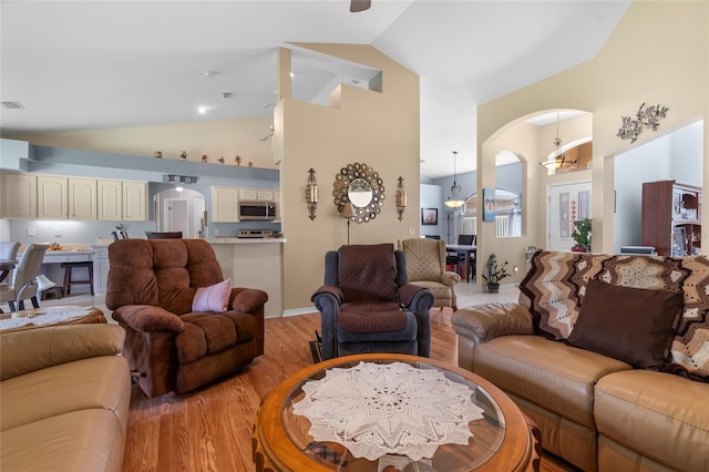 living room featuring high vaulted ceiling, ceiling fan, and light hardwood / wood-style flooring