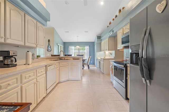 kitchen featuring pendant lighting, stainless steel appliances, light tile patterned floors, sink, and cream cabinets