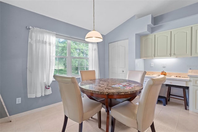 tiled dining room featuring vaulted ceiling