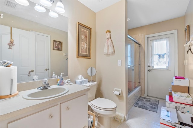 full bathroom featuring tile patterned flooring, vanity, toilet, and shower / bath combination with glass door