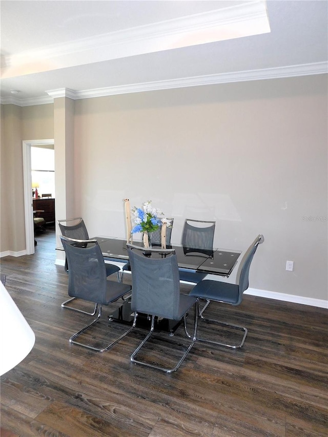 dining area with ornamental molding and dark hardwood / wood-style flooring