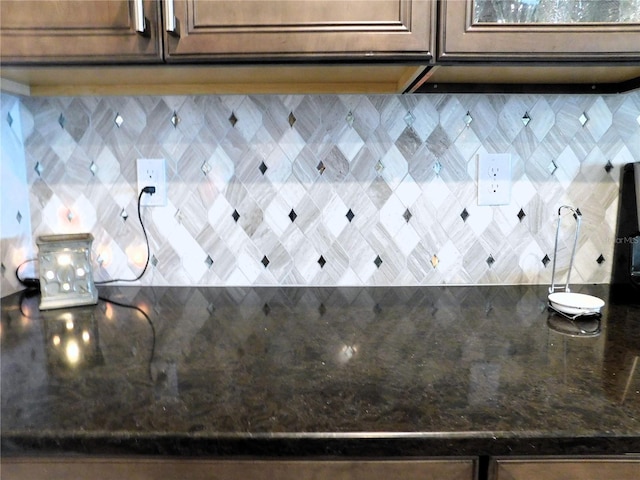 room details featuring dark stone countertops and tasteful backsplash