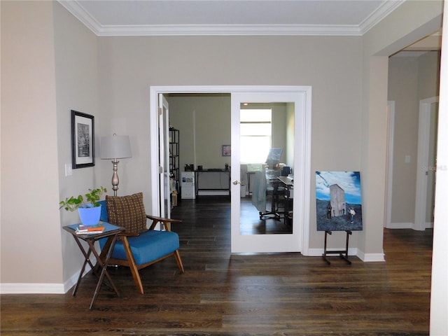 sitting room with ornamental molding and dark wood-type flooring