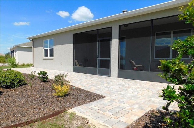 back of house with a sunroom and a patio