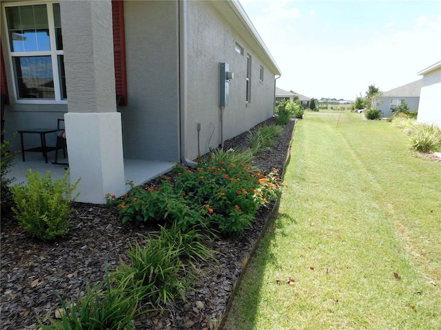 view of side of property with a yard and a patio area