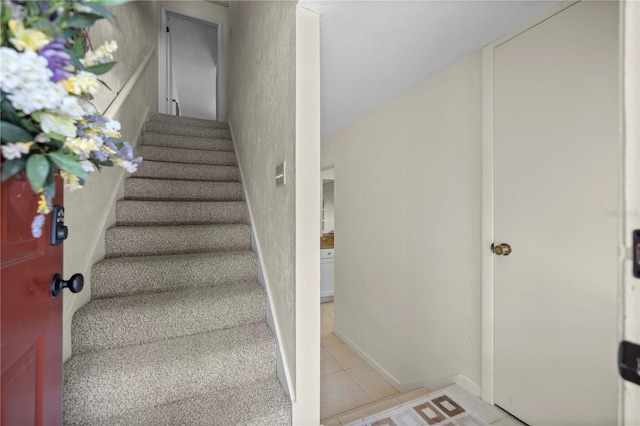 stairway featuring tile patterned flooring