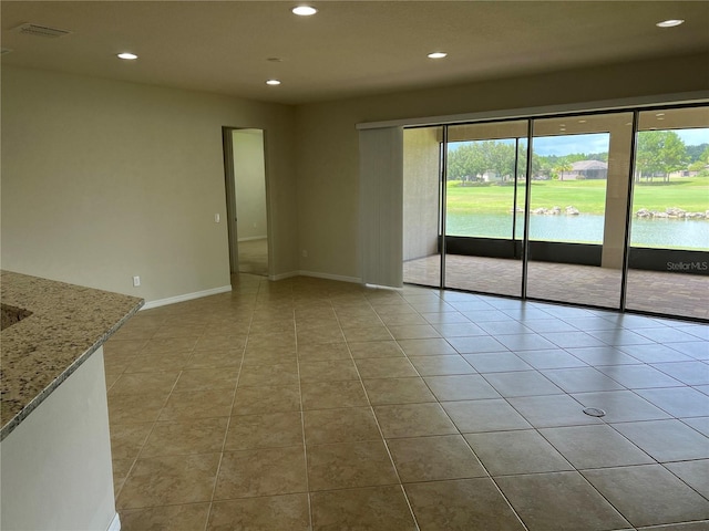 tiled spare room with a water view