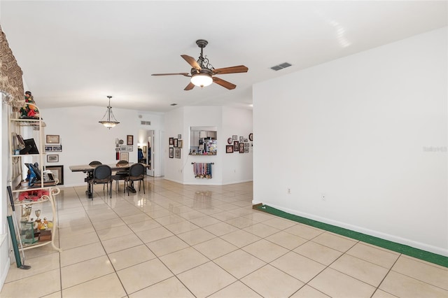 living room with ceiling fan, light tile patterned floors, and lofted ceiling