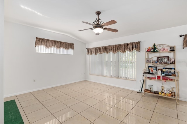 unfurnished room featuring ceiling fan, light tile patterned floors, and lofted ceiling