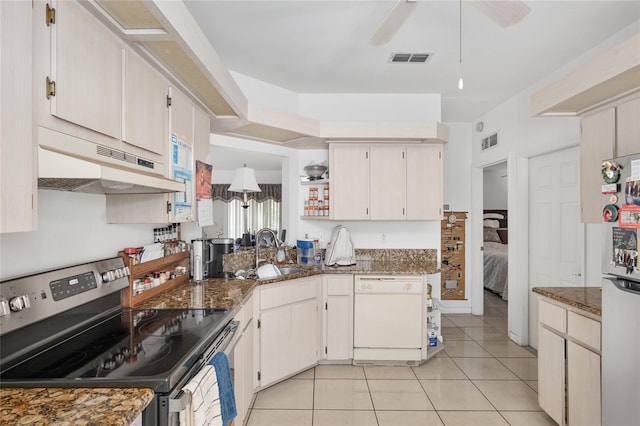 kitchen featuring sink, light tile patterned floors, white appliances, and dark stone countertops