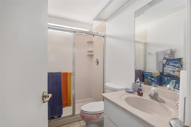 bathroom featuring toilet, tile patterned flooring, vanity, and walk in shower