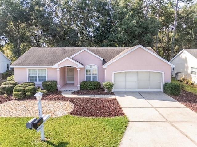 11696 SW 71st Cir, Ocala, FL 34476 - ranch-style house with concrete driveway, a shingled roof, a garage, stucco siding, and central air condition unit
