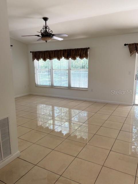 11696 SW 71st Cir, Ocala, FL 34476 - spare room with light tile patterned flooring, a ceiling fan, and baseboards