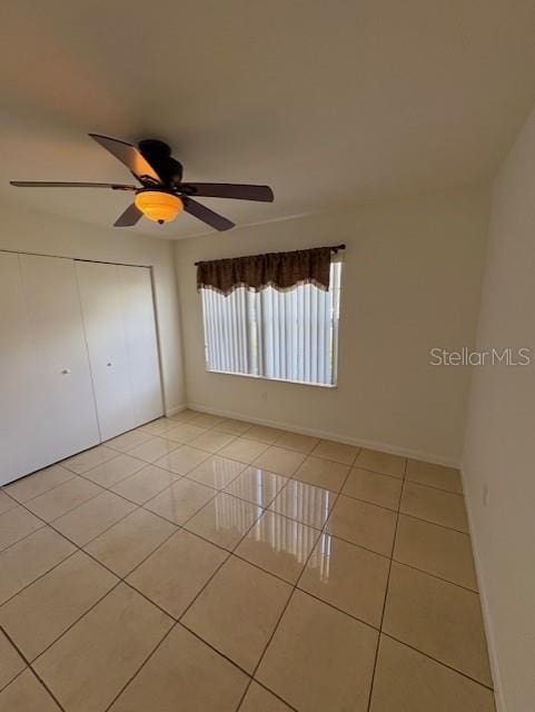11696 SW 71st Cir, Ocala, FL 34476 - unfurnished bedroom featuring light tile patterned floors, a closet, a ceiling fan, and baseboards