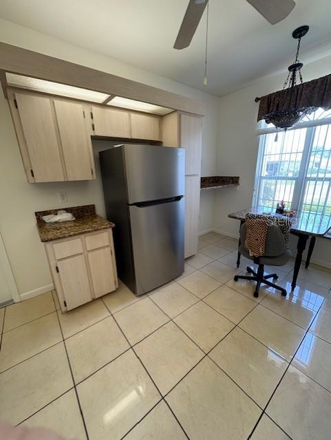 11696 SW 71st Cir, Ocala, FL 34476 - kitchen with freestanding refrigerator, light tile patterned floors, a ceiling fan, baseboards, and dark countertops