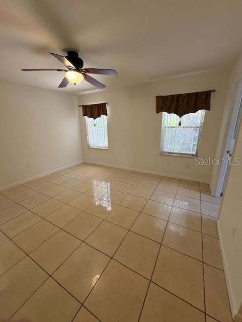 11696 SW 71st Cir, Ocala, FL 34476 - unfurnished room with light tile patterned flooring, ceiling fan, and baseboards
