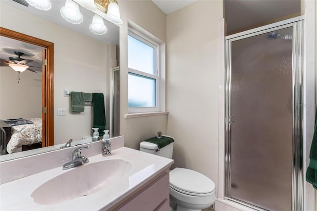 bathroom featuring vanity, toilet, walk in shower, and ceiling fan