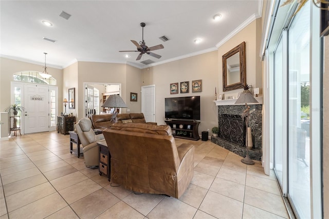 tiled living room featuring ceiling fan, a fireplace, and ornamental molding