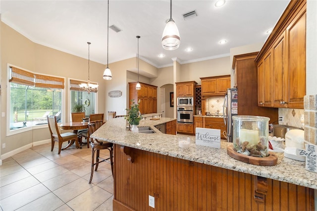 kitchen with a kitchen breakfast bar, backsplash, light stone countertops, stainless steel appliances, and kitchen peninsula