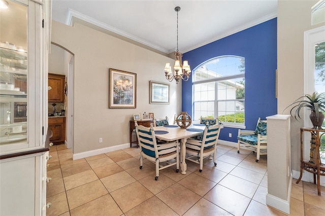 tiled dining room featuring an inviting chandelier and crown molding